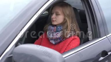 穿着红色保暖外套和五颜六色围巾的漂亮女人坐在车里
